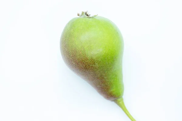 Madura hermosa pera verde se encuentra sobre un fondo blanco — Foto de Stock