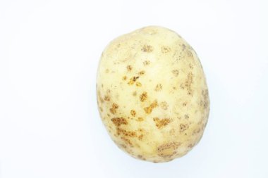 Soyulmamış patatesler beyaz arka planda tünemiş.