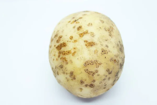 Pommes de terre non pelées perchées sur un fond blanc — Photo