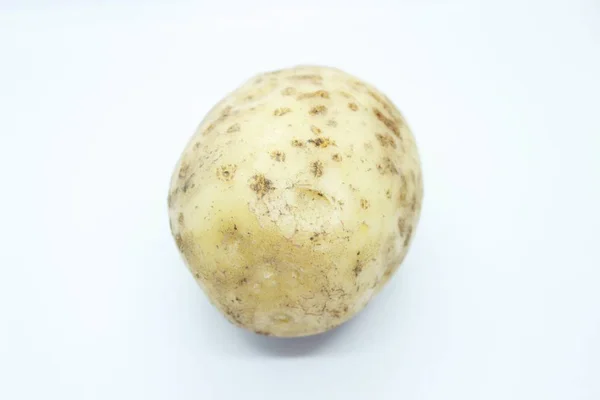 Unpeeled potatoes perched on a white background — Stock Photo, Image