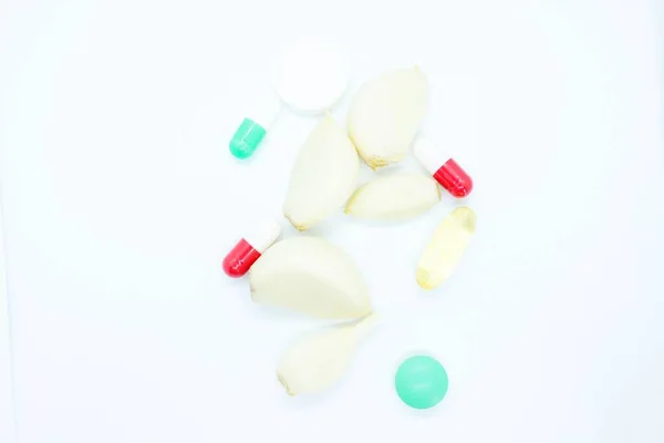 Hřebíček česnek pilulka vitamíny se nachází na bílém pozadí — Stock fotografie