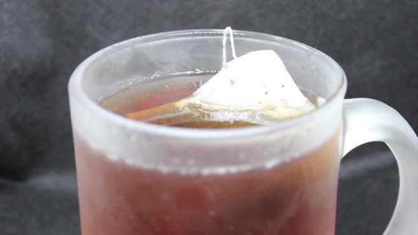 黒の背景に強い熱いお茶と透明マグカップ — ストック動画