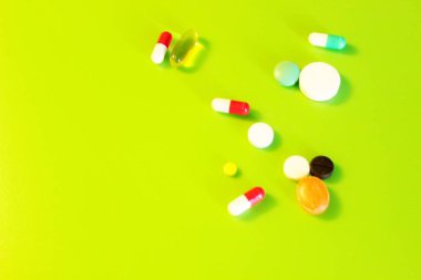 Yeşil arka planda bulunan haplar vitamin ilaçları.