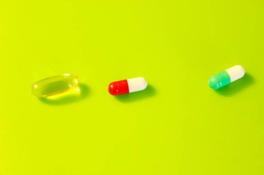 Yeşil arka planda bulunan haplar vitamin ilaçları.
