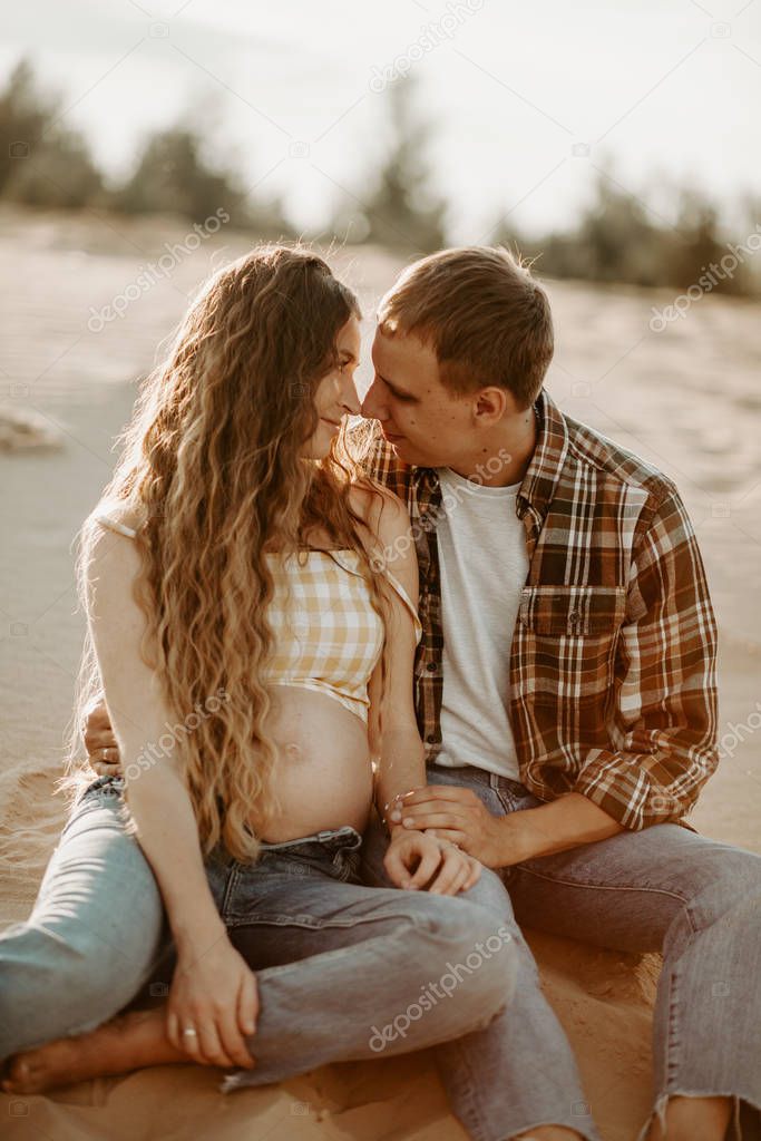 young beautiful couple, pregnant woman with husband posing outdoors 