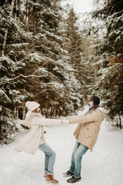Mutlu çift, karlı kış ormanlarında eğleniyor. 