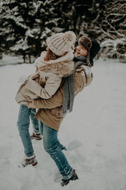 Mutlu çift, karlı kış ormanlarında eğleniyor. 