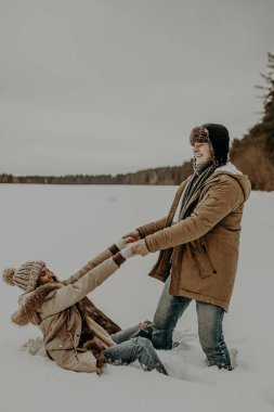 Genç çift kış ormanlarında poz veriyor. 