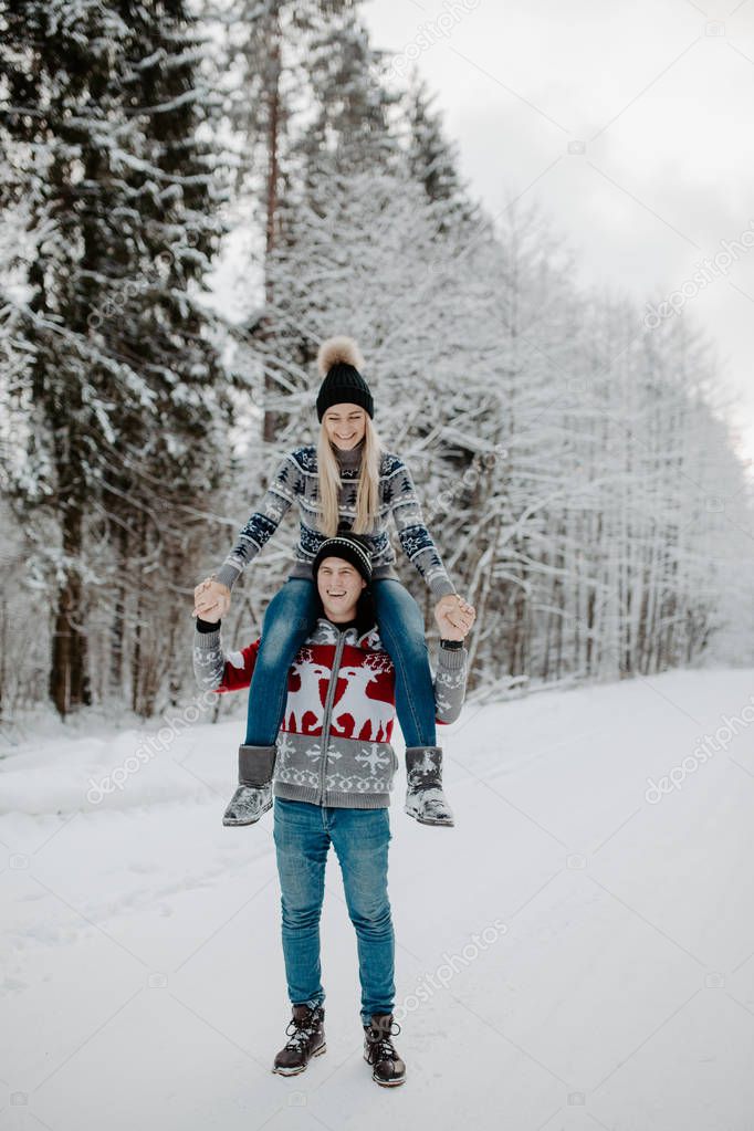 happy couple enjoying in the snowy winter forest . Christmas mood.  