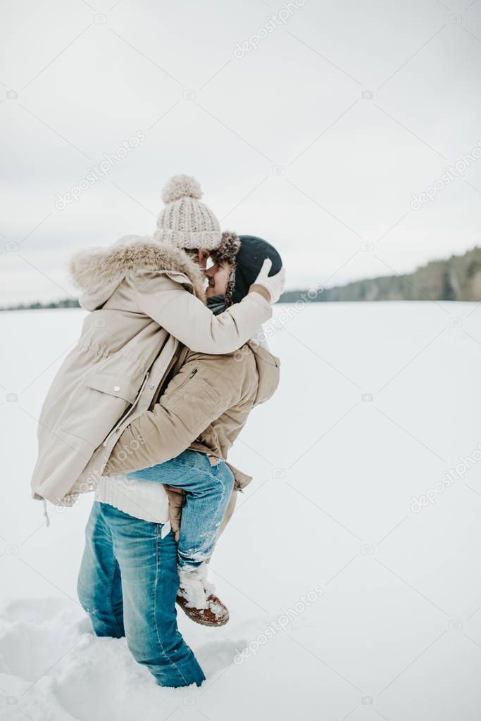 young couple in love posing in winter forest 