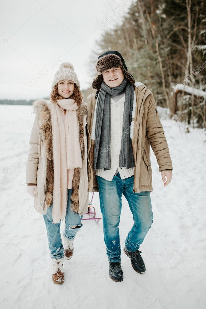 young couple in love posing in winter forest 