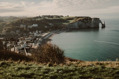 Falaise d 'Aval kıyısındaki kıyı manzarası Etretat köyünün ünlü beyaz uçurumları Porte d' Aval doğal kemeri ve Aiguille d 'Etretat olarak bilinen kayayla birlikte.