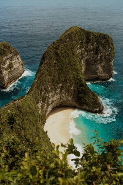 Uçurumun eteğindeki vahşi tropik plaj. Kayalık kayalıkların arasında tropik bir sahil. Endonezya, Bali 'deki Nusa Penida Adası' ndaki Manta Körfezi veya Kelingking Sahili. Popüler yer