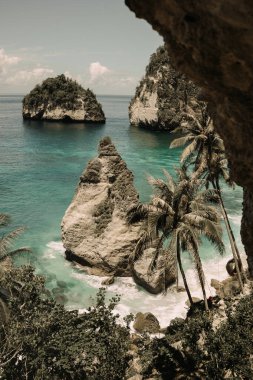 Uçurumun eteğindeki vahşi tropik plaj. Kayalık kayalıkların arasında tropik bir sahil. Endonezya, Bali 'deki Nusa Penida Adası' ndaki Manta Körfezi veya Kelingking Sahili. Popüler yer