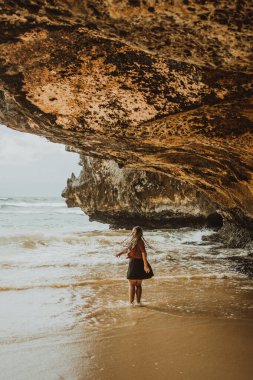 Sahilde yürüyen genç bir kız. 