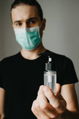 Elinde dezenfektan jel pompası olan adam, COVID-19 konsepti.