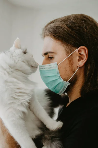 Homem Alegre Com Uma Máscara Médica Com Gato Branco Auto Imagens De Bancos De Imagens Sem Royalties