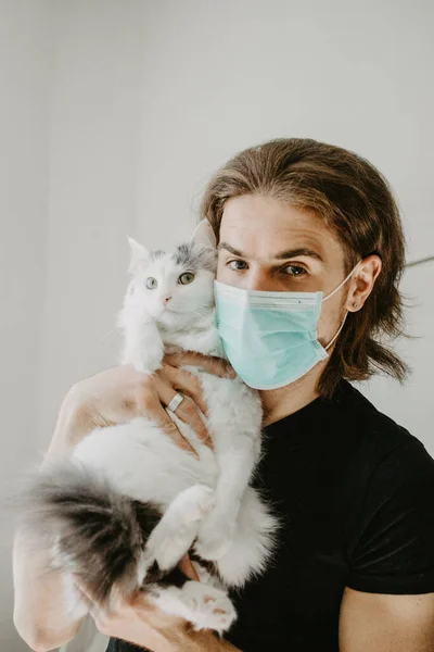 Homem Alegre Com Uma Máscara Médica Com Gato Branco Auto Fotos De Bancos De Imagens Sem Royalties
