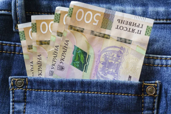 Украинские деньги. Новые банкноты 500 гривен купюры гривны в заднем кармане синих джинсов. Концепция денег, коррупция . — стоковое фото
