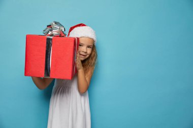  Noel Baba 'nın kırmızı şapkalı kızı Noel hediyesi taşıyor.