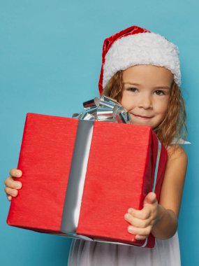  Noel Baba 'nın kırmızı şapkalı kızı Noel hediyesi taşıyor.