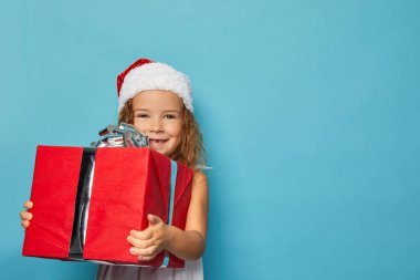  Noel Baba 'nın kırmızı şapkalı kızı Noel hediyesi taşıyor.