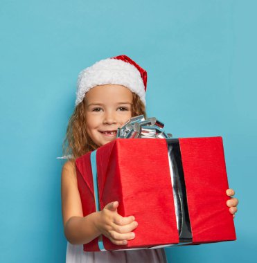  Noel Baba 'nın kırmızı şapkalı kızı Noel hediyesi taşıyor.