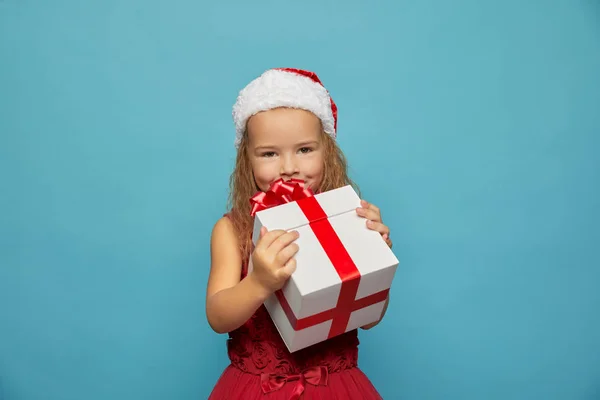 Flicka i Santa röd hatt håller julklapp — Stockfoto