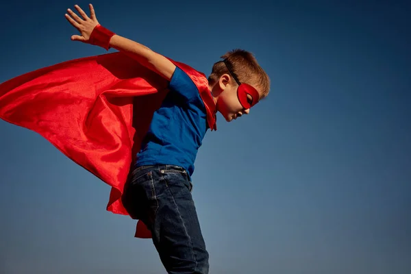 Criança super-herói (menino) contra o céu azul — Fotografia de Stock