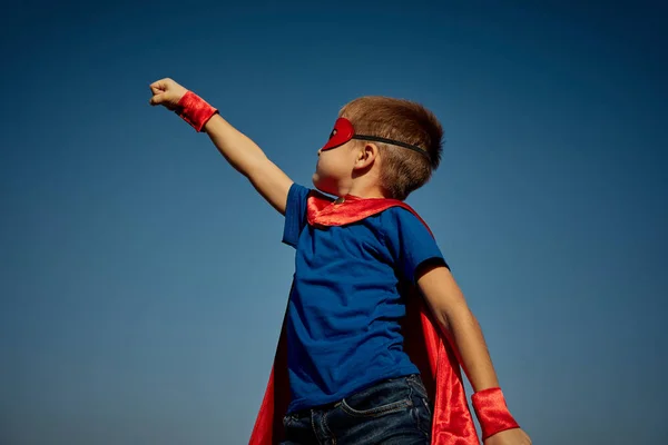 Criança super-herói (menino) contra o céu azul — Fotografia de Stock