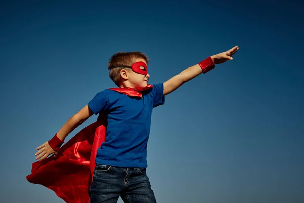Супергерой-ребенок (мальчик) на фоне голубого неба — стоковое фото