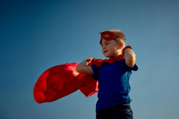 Criança super-herói (menino) contra o céu azul — Fotografia de Stock