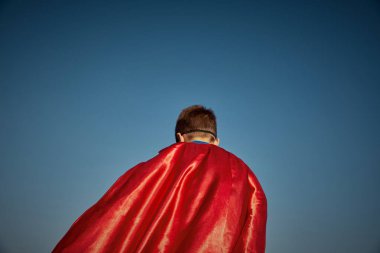 Süper kahraman çocuk mavi gökyüzüne karşı