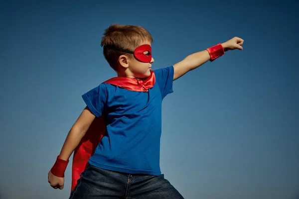 Super héroe niño (niño) contra el cielo azul — Foto de Stock