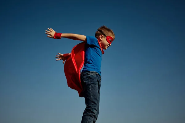 Super héroe niño (niño) contra el cielo azul — Foto de Stock