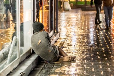Eminonu, Istanbul / Turkey - March 05 2020: Homeless boy begging on the street on a rainy day