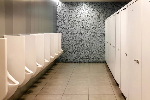 Erkekler için modern umumi tuvalet. Beyaz fayanslardan temiz ve hijyenik pisuar. Halk tuvaleti.