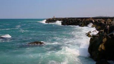 Deniz dalgaları dalgalanan sulara çarpar. Güneşli yaz günü deniz dalgaları manzarası