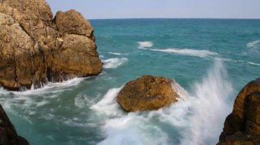 Mavi deniz dalgaları kayalara çarpıyor. Güneşli yaz günü deniz dalgaları manzarası