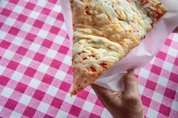 Vista dall'alto di una mano che appende una fetta di pizza alla mozzarella — Foto Stock