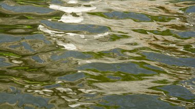 Suyun yüzeyinde beyaz, sarı ve yeşil renkli güzel ve sakin bir yansıma.