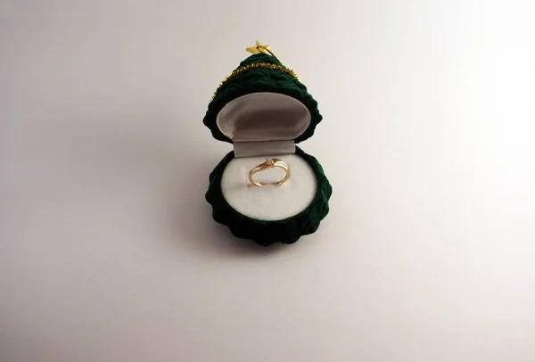 A gift, a gold ring with diamonds in a box in the form of a festive tree.