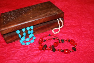 Casket with beads, jewelry on a bright background.