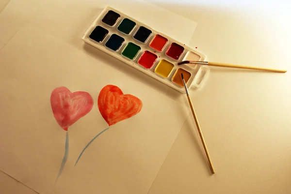 A palette of watercolors and brushes, accessories for the artist, heart.