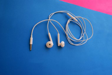 Akıllı bir telefon için kulaklık, parlak bir arka plan, modern teknoloji..