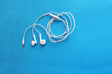 Akıllı bir telefon için kulaklık, parlak bir arka plan, modern teknoloji..