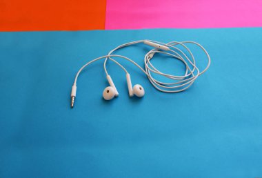 Akıllı bir telefon için kulaklık, parlak bir arka plan, modern teknoloji..