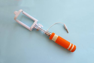 Parlak bir arka planda selfie çubuğu, modern teknoloji.