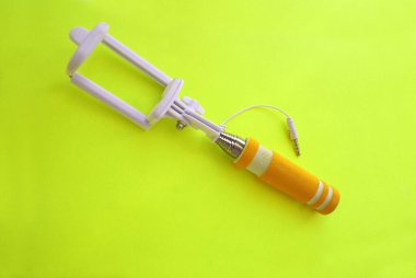 Parlak bir arka planda selfie çubuğu, modern teknoloji.