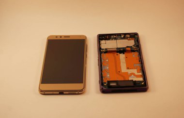 Altın akıllı telefon ve sökülmüş telefon, modern teknoloji.